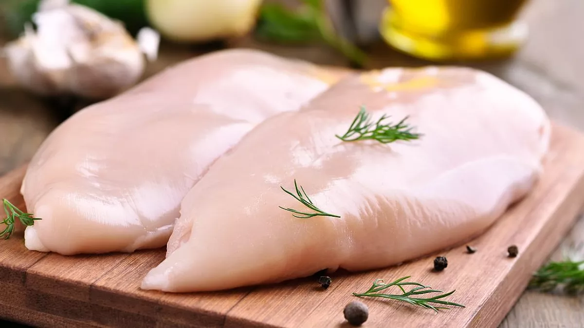 Petto di pollo crudo su tagliere