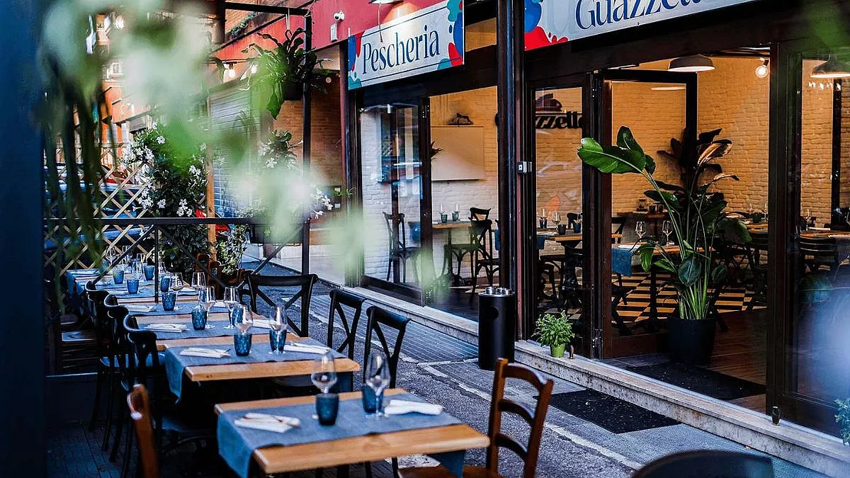 Veduta esterna con i tavoli di un ristorante di pesce a Roma, chiamato Guazzetto