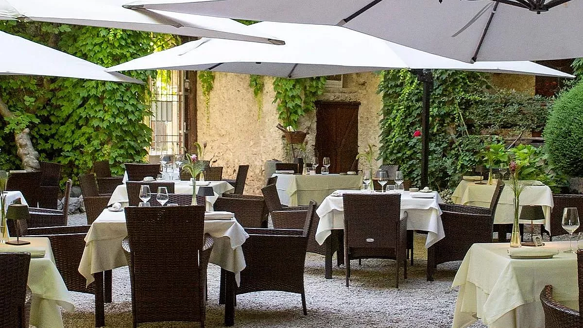 Immagine del ristorante La Corte degli Dei, che mostra i tavoli apparecchiati con gli ombrelloni da ristorante