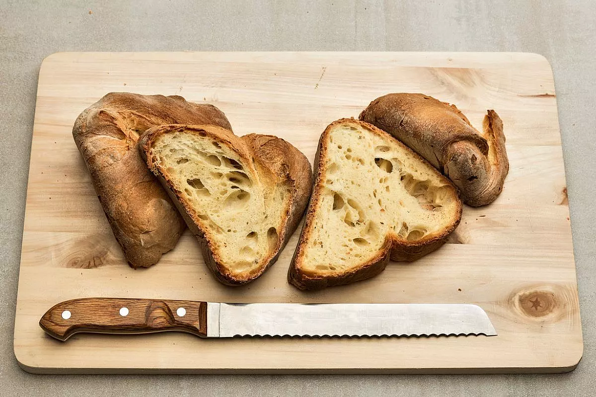Pane di Altamura a fette, su un tagliere ed un coltello da pane