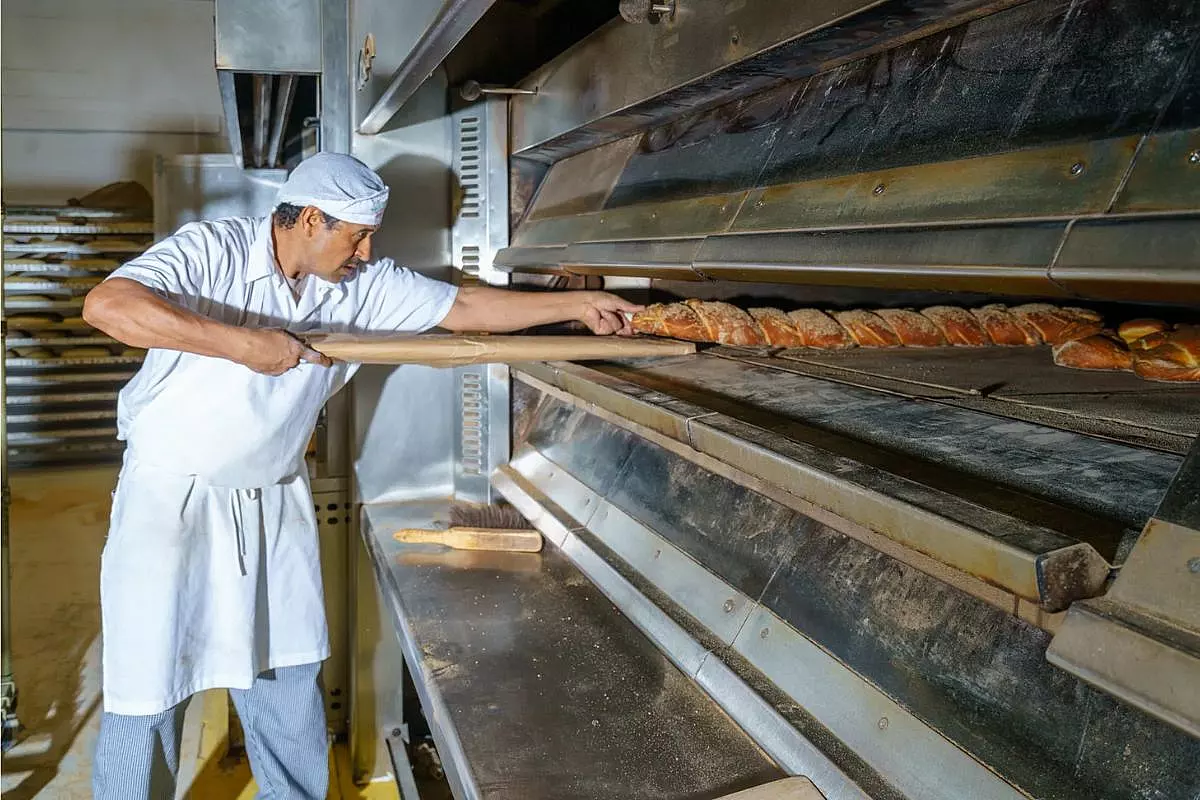 Un panettiere che sforna un pane da quasi 2 metri