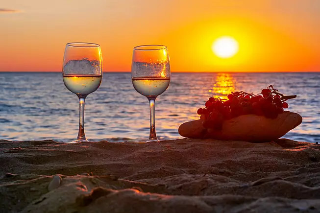 bicchieri di vino al tramonto sul mare di Sicilia