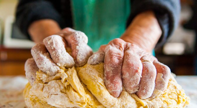 old italian lady's hands preparing home made italian pasta