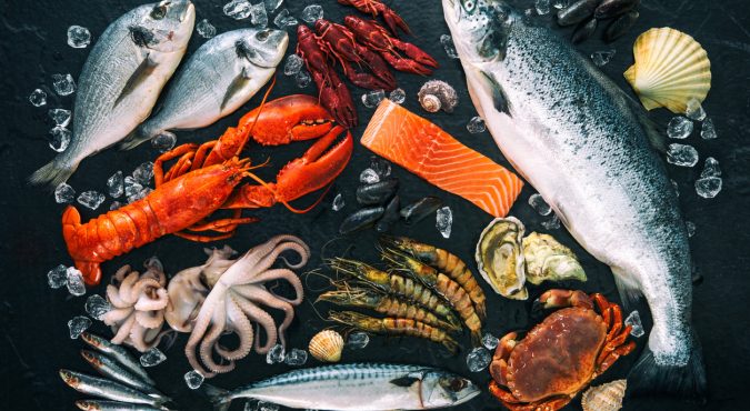 Fresh fish and seafood arrangement on black stone